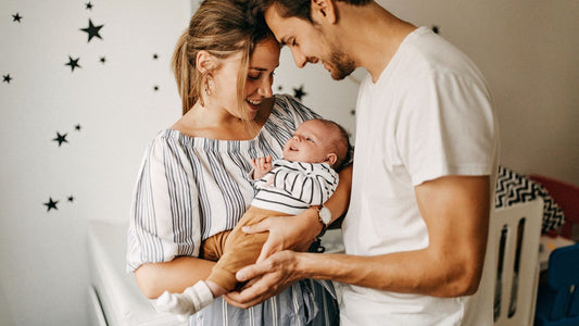 Couple holding new baby boy in nursery