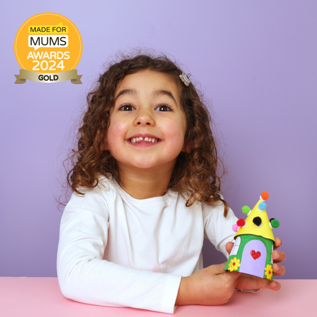 Child holding a colorful toy house with 'Made for Mums Awards 2024 Gold' badge on a purple background