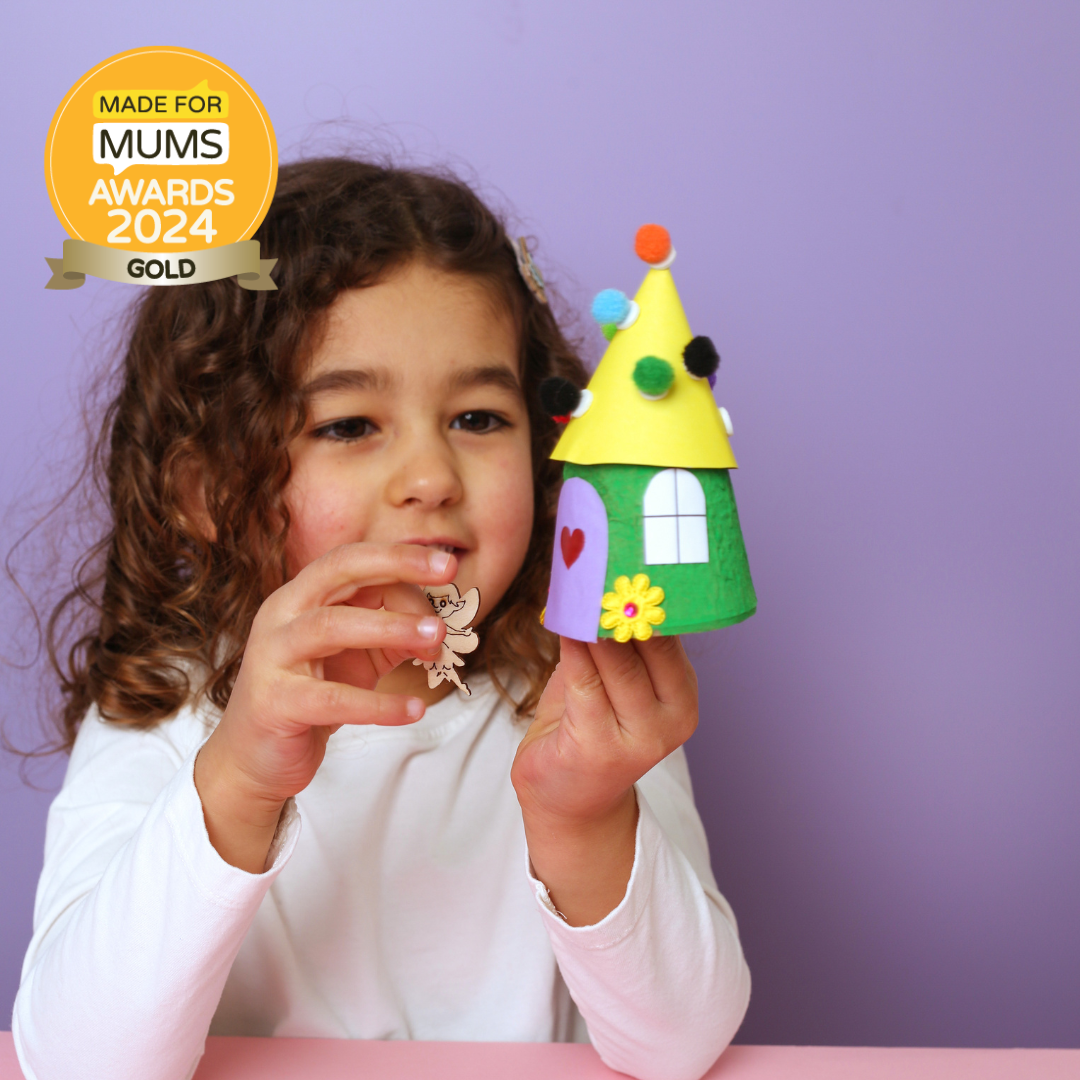 Child holding a colorful craft house with 'Made for Mums Awards 2024 Gold' badge on a purple background