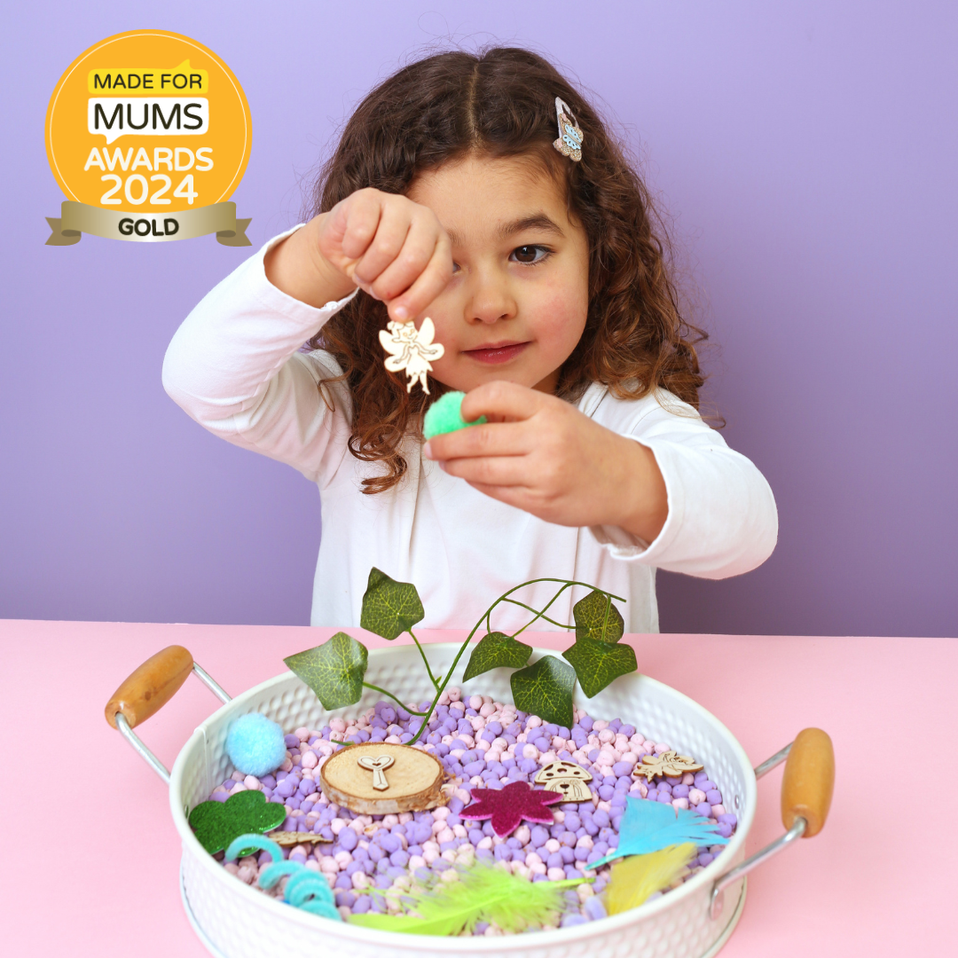 Child playing with a sensory bin filled with colorful materials, with a 'Made for Mums Awards 2024 Gold' badge in the corner.