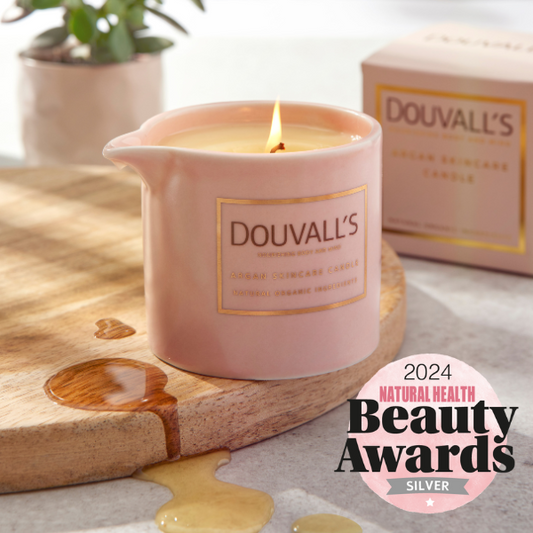 Pink Douvall's candle on a wooden board with a 2024 Natural Health Beauty Awards badge.