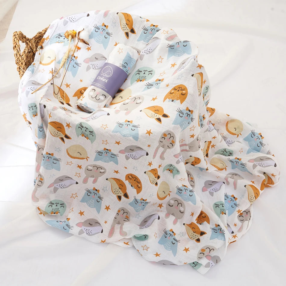 Baby blanket with animal pattern and a bottle on a white surface