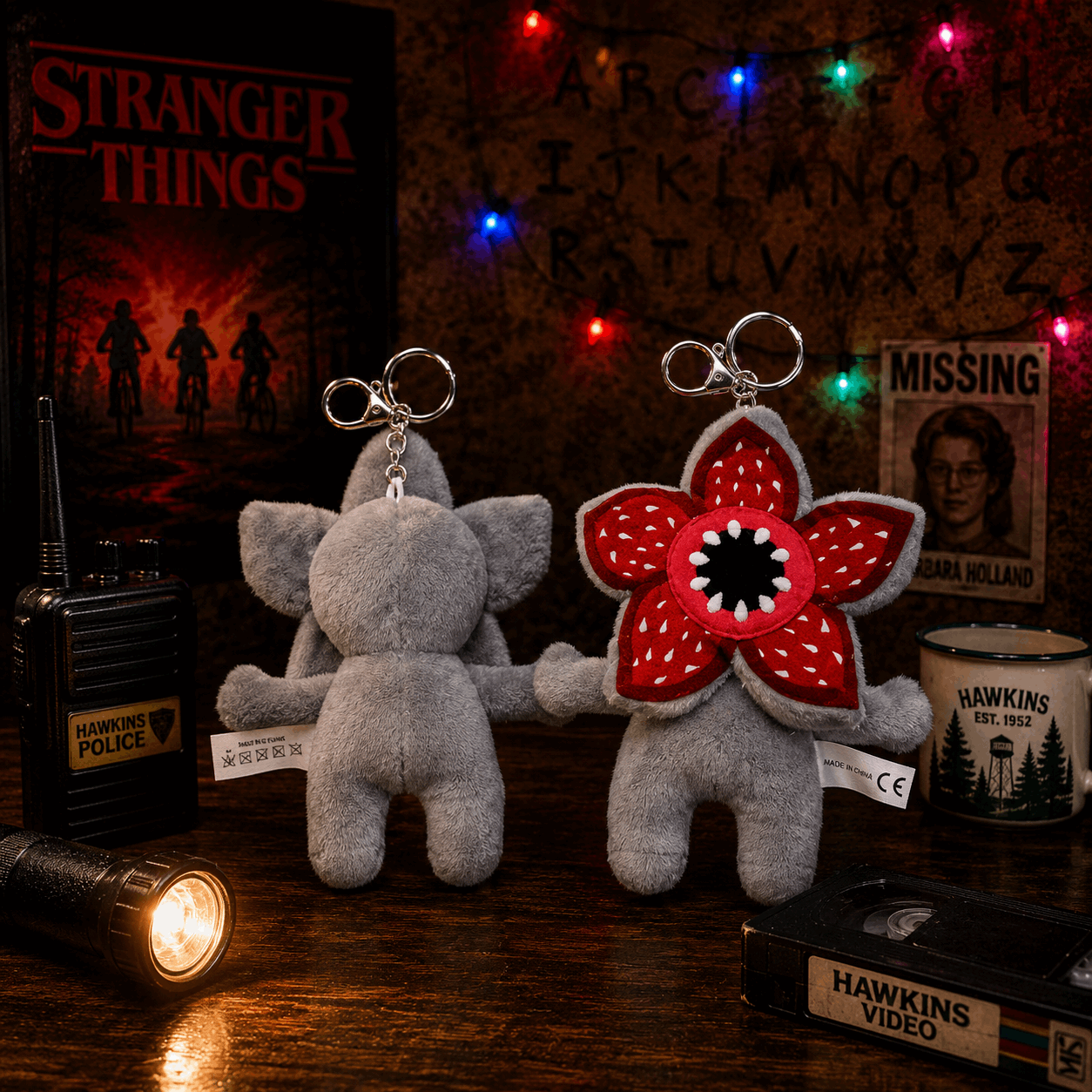 Two plush keychains resembling characters from 'Stranger Things' on a table with decorative items.