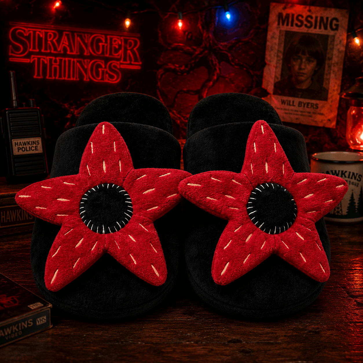 Black slippers with red star design on a dark background with 'Stranger Things' theme.