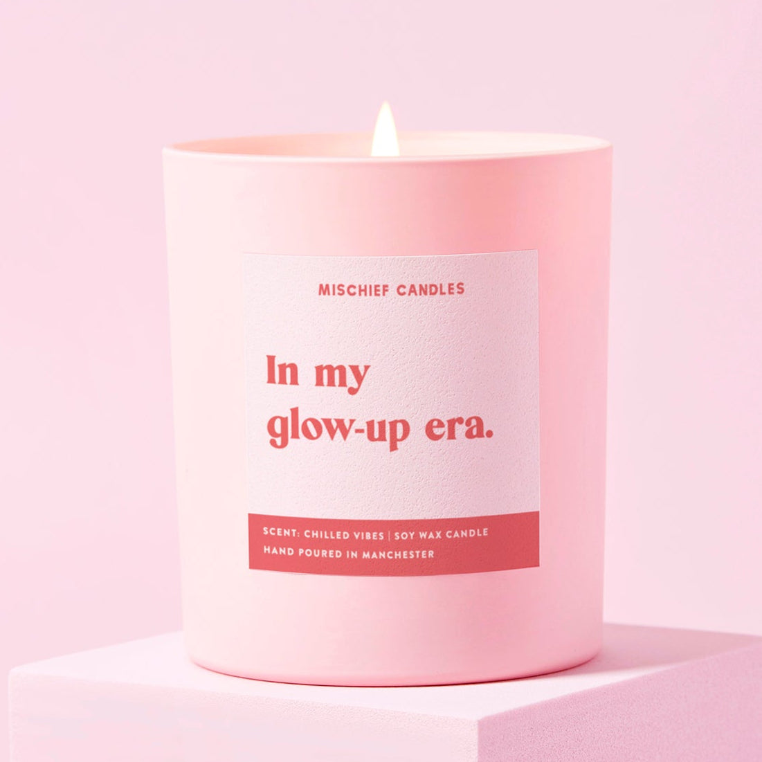 Pink candle with a label on a pink background