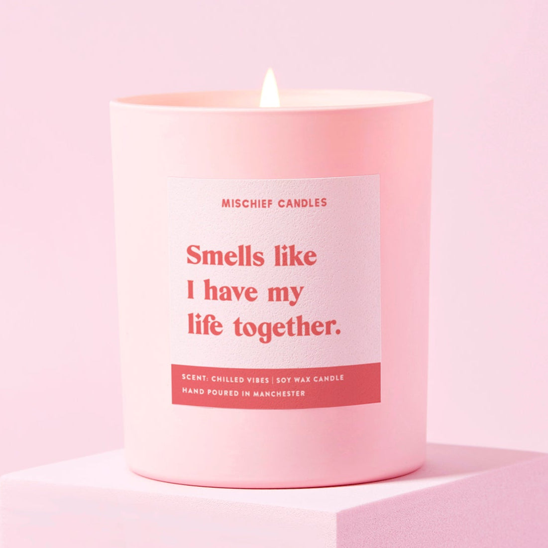 Pink candle with a label on a pink background
