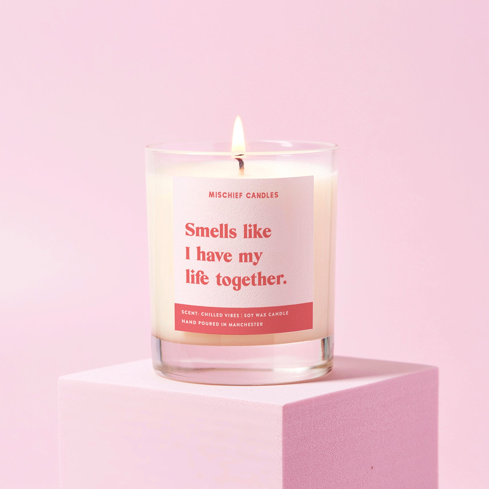 Candle with a humorous label on a pink background