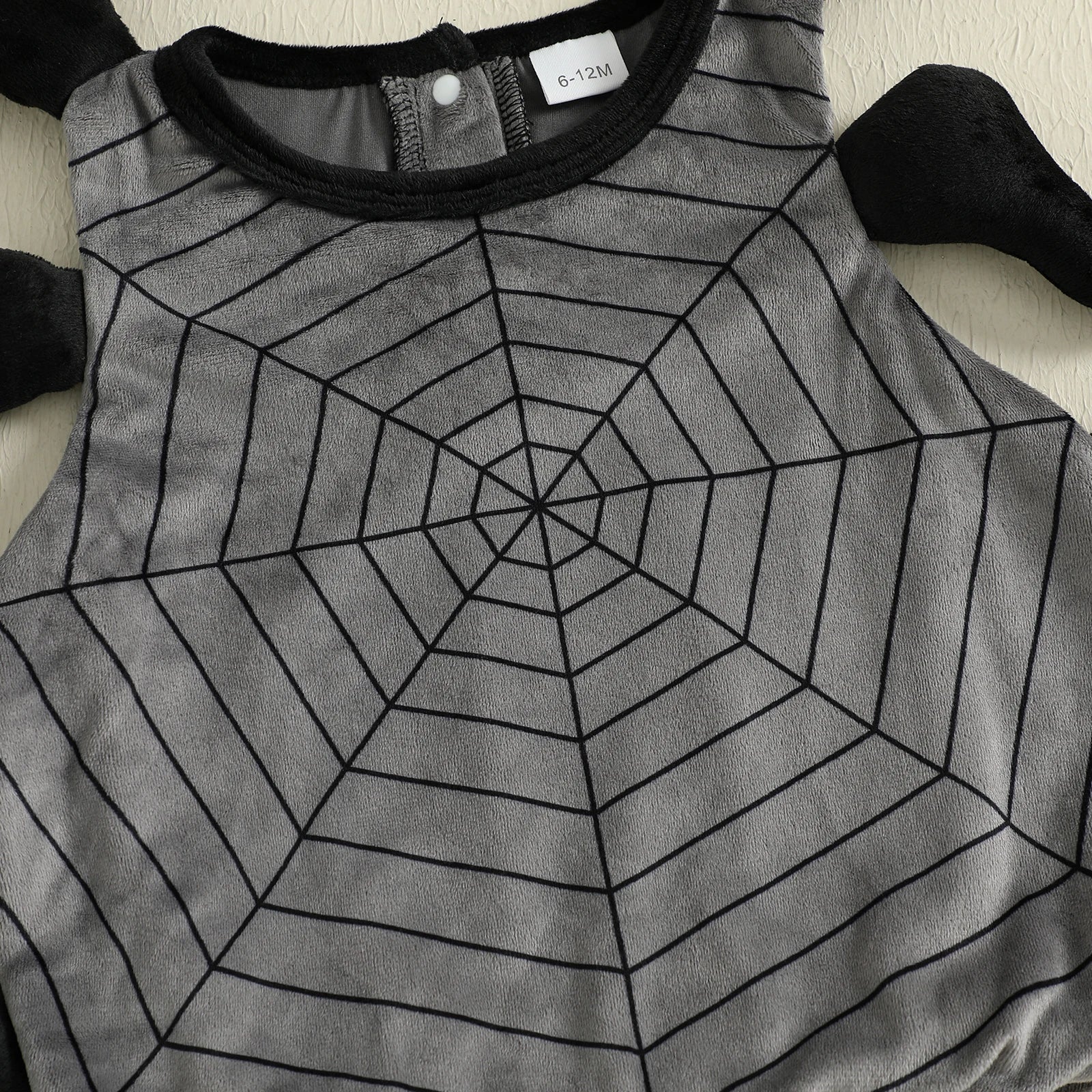 Gray shirt with black spider web pattern on a white background