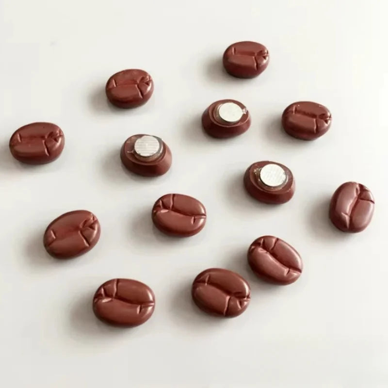 Fridge magnet shaped like coffee beans on a white surface