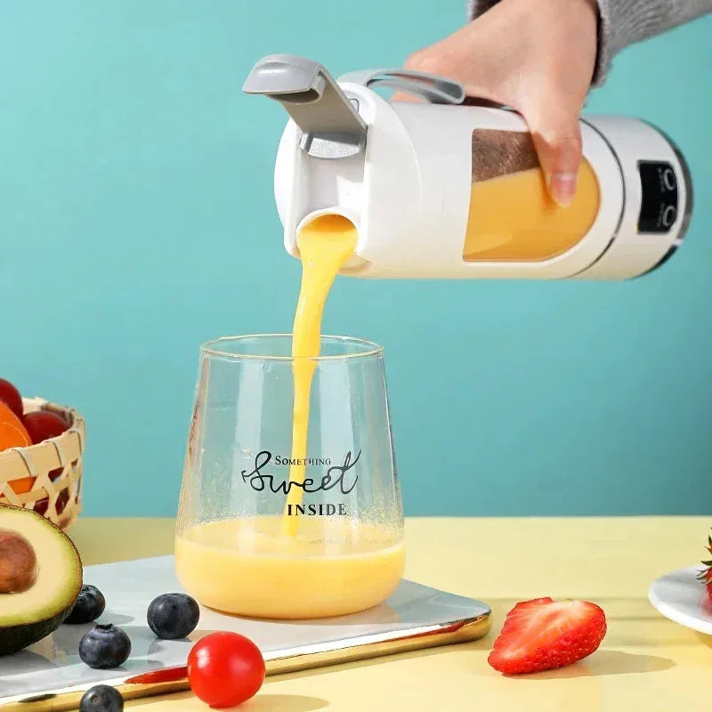 Hand pouring orange juice from a white and silver pitcher into a glass with fruit on a table.