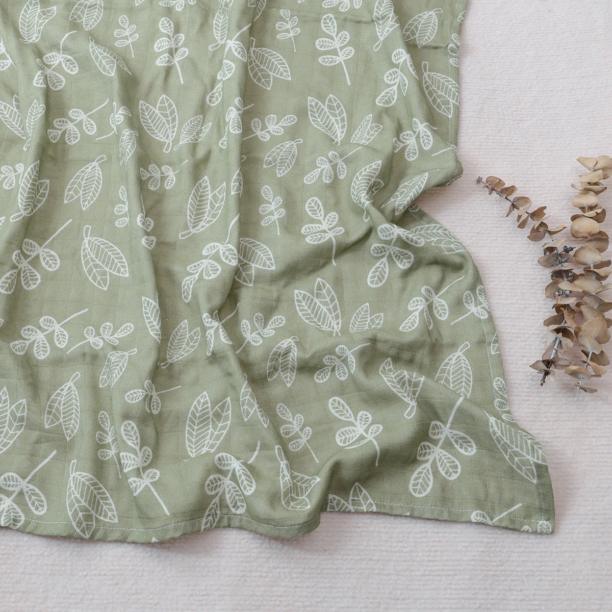 Green fabric with white leaf pattern on a light background