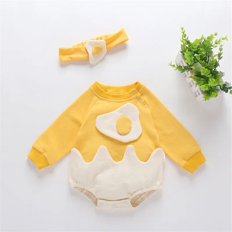Yellow and white baby outfit with a matching headband on a light gray background