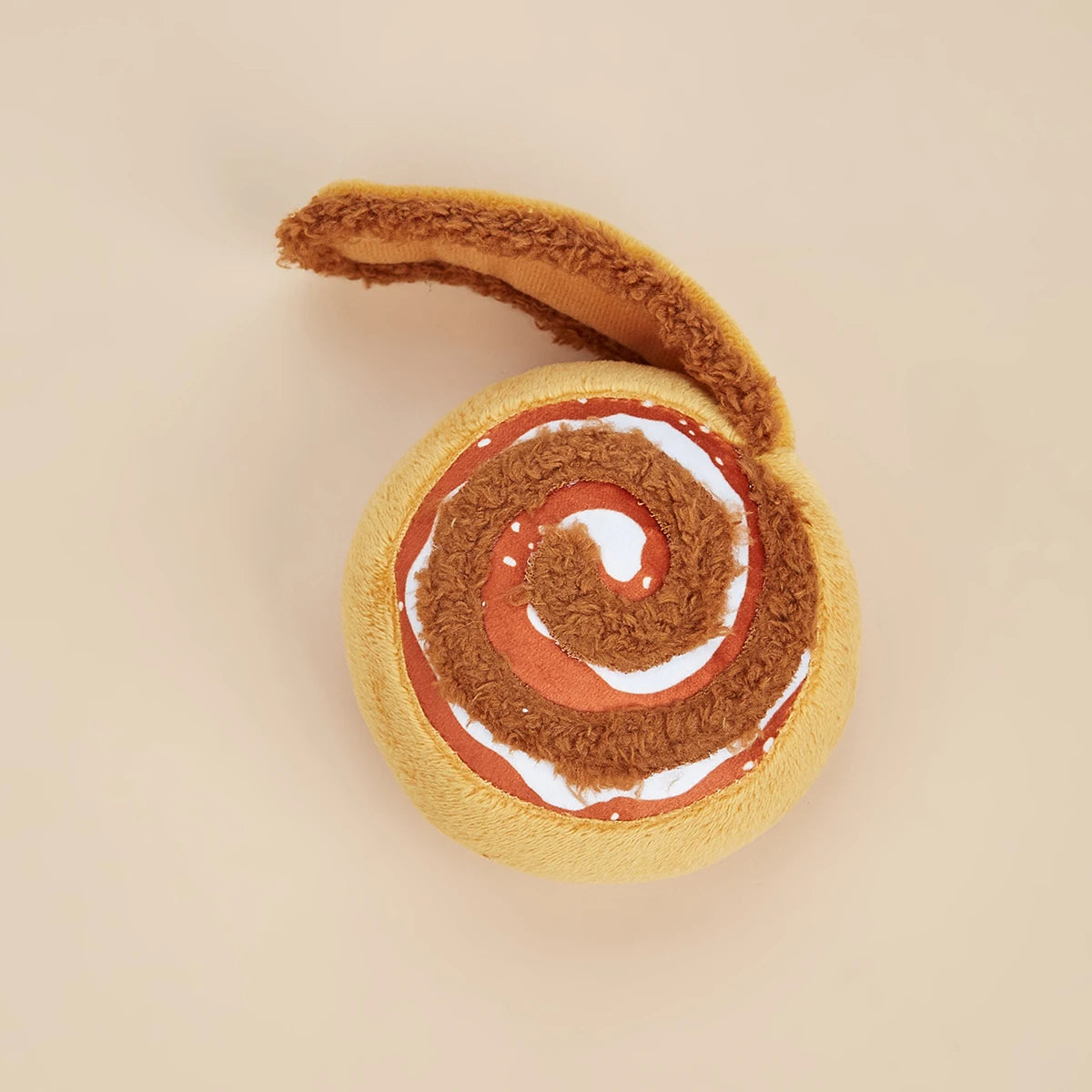 Toy resembling a cinnamon roll on a beige background