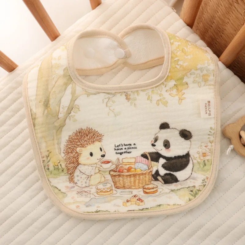 Baby bib with cartoon hedgehog and panda design on a crib mattress