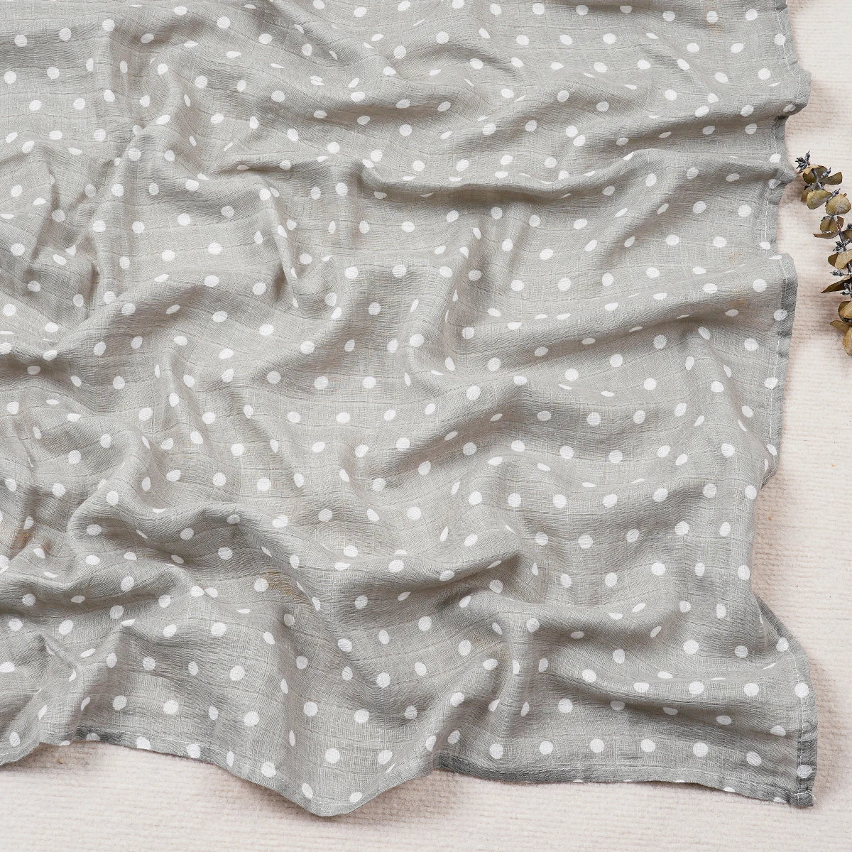 Gray fabric with white polka dots on a light wooden surface