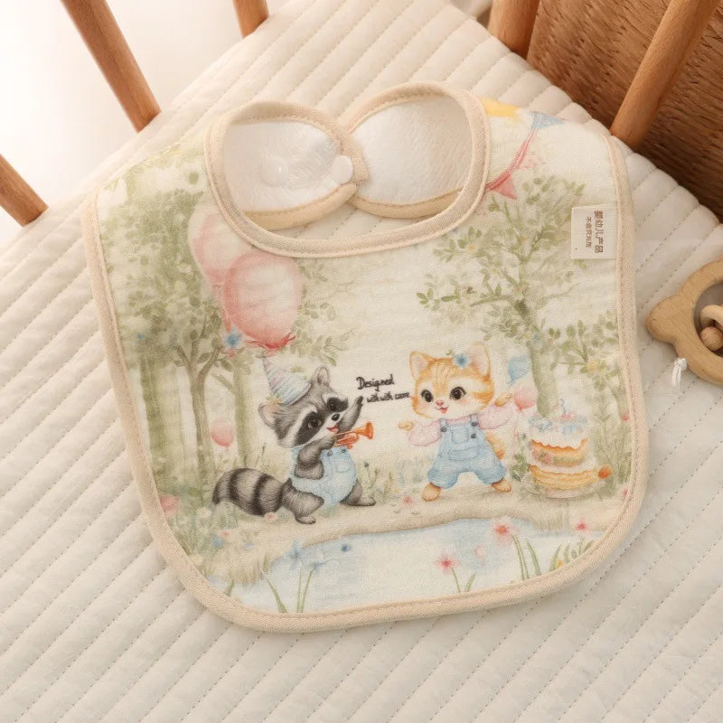 Baby bib with cartoon raccoon and cat design on a soft surface
