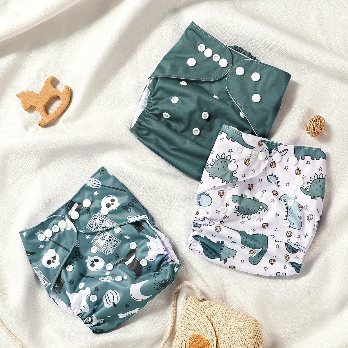 Three baby diapers with different patterns on a white surface