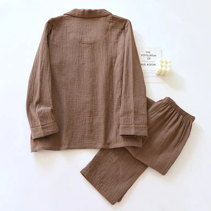 Brown shirt and pants set on a white surface with a book in the background