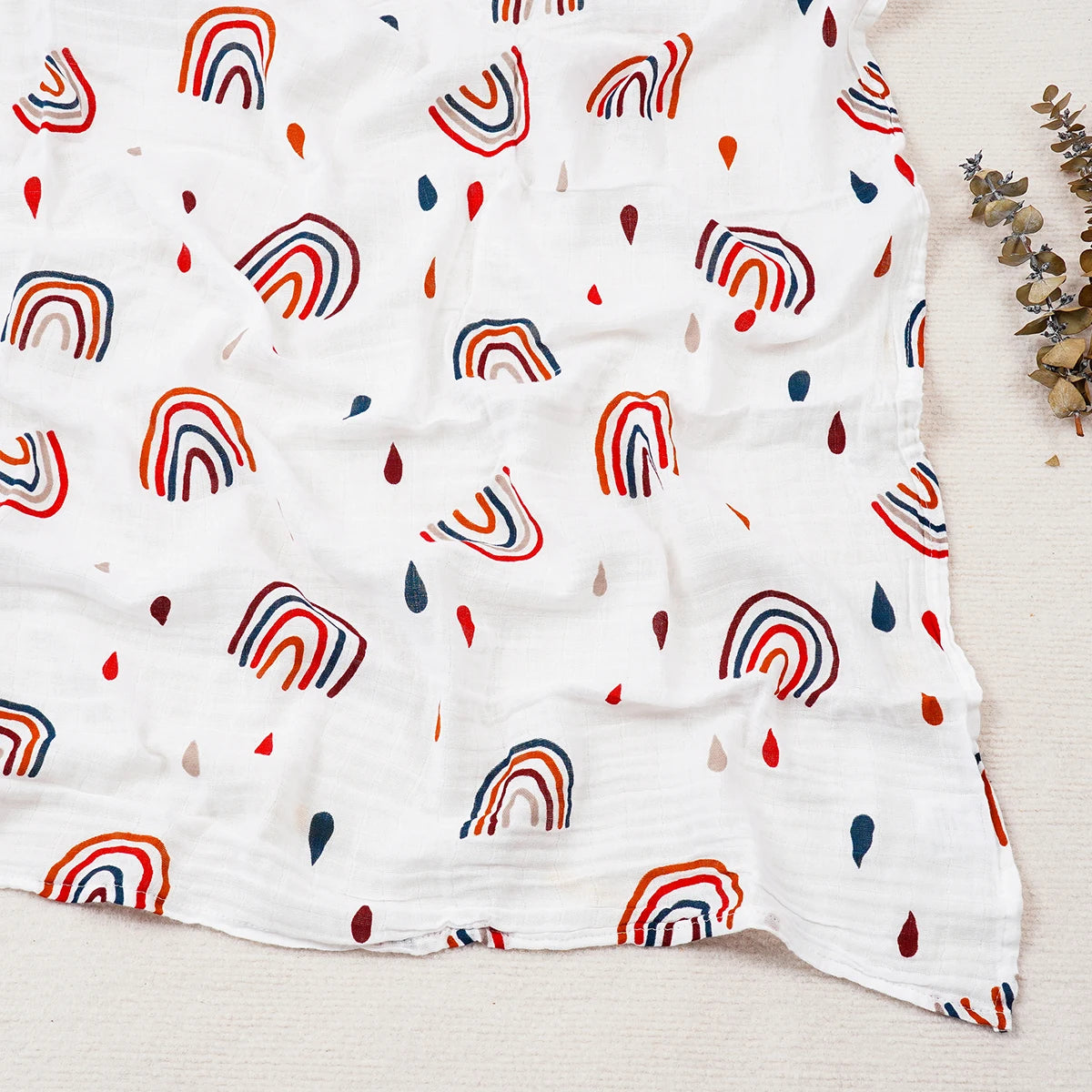 White blanket with colorful rainbow pattern on a light wooden surface