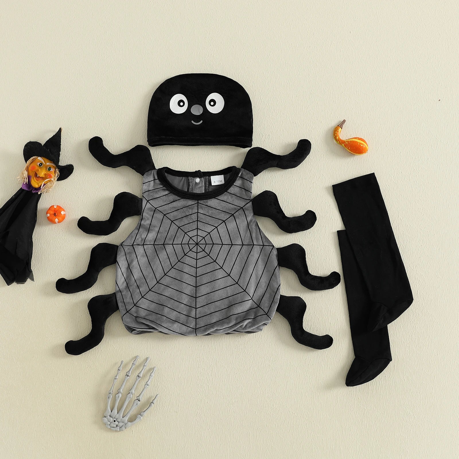 Children's Halloween costume set with spider design on a beige background