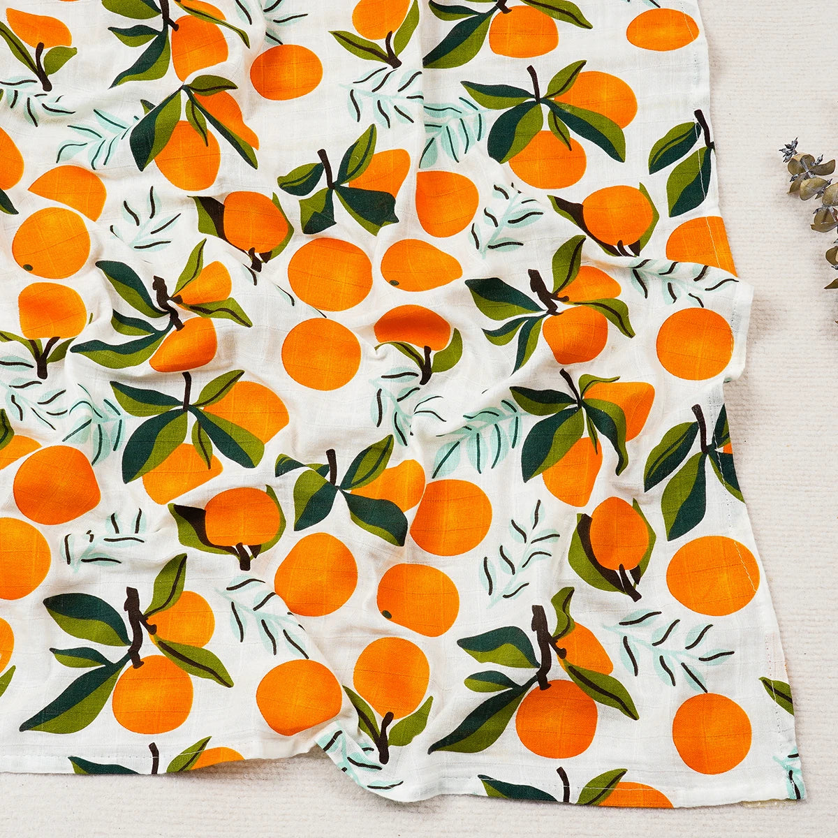Fabric with a pattern of oranges and leaves on a white background