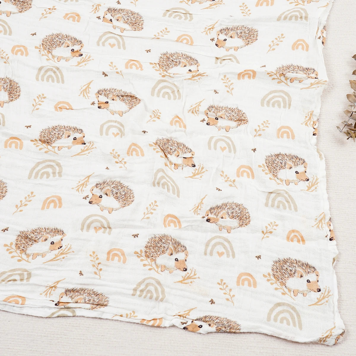 muslin blanket with hedgehog and rainbow pattern on a white background