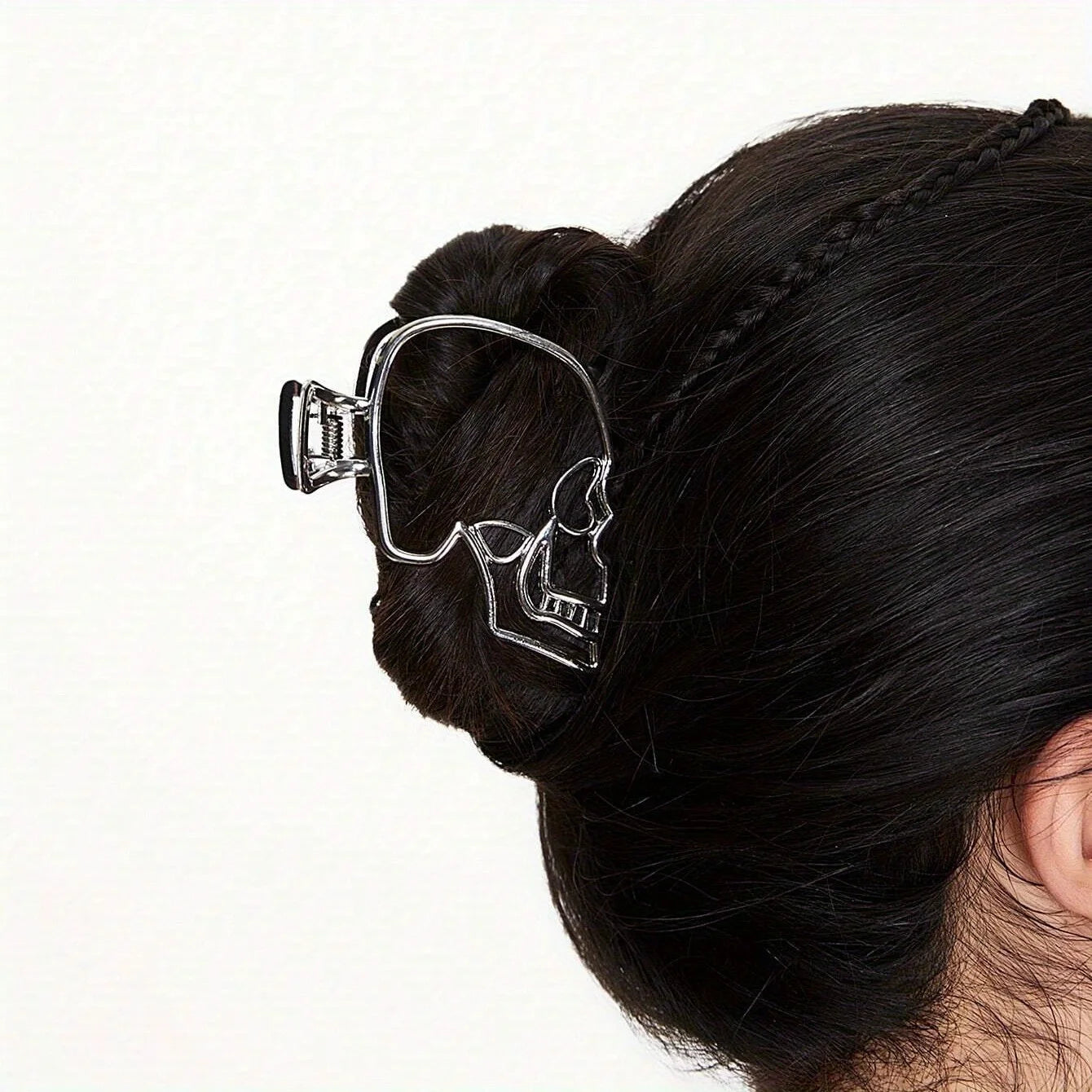 Hair clip with a skull design in a bun on a white background