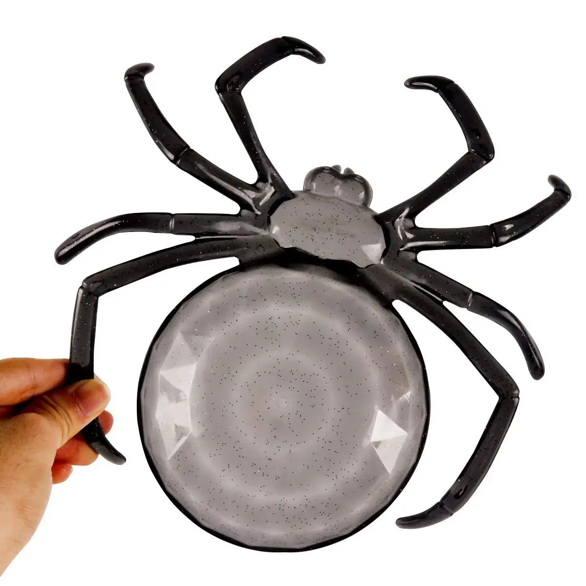Spider-shaped object with a hand holding it on a white background