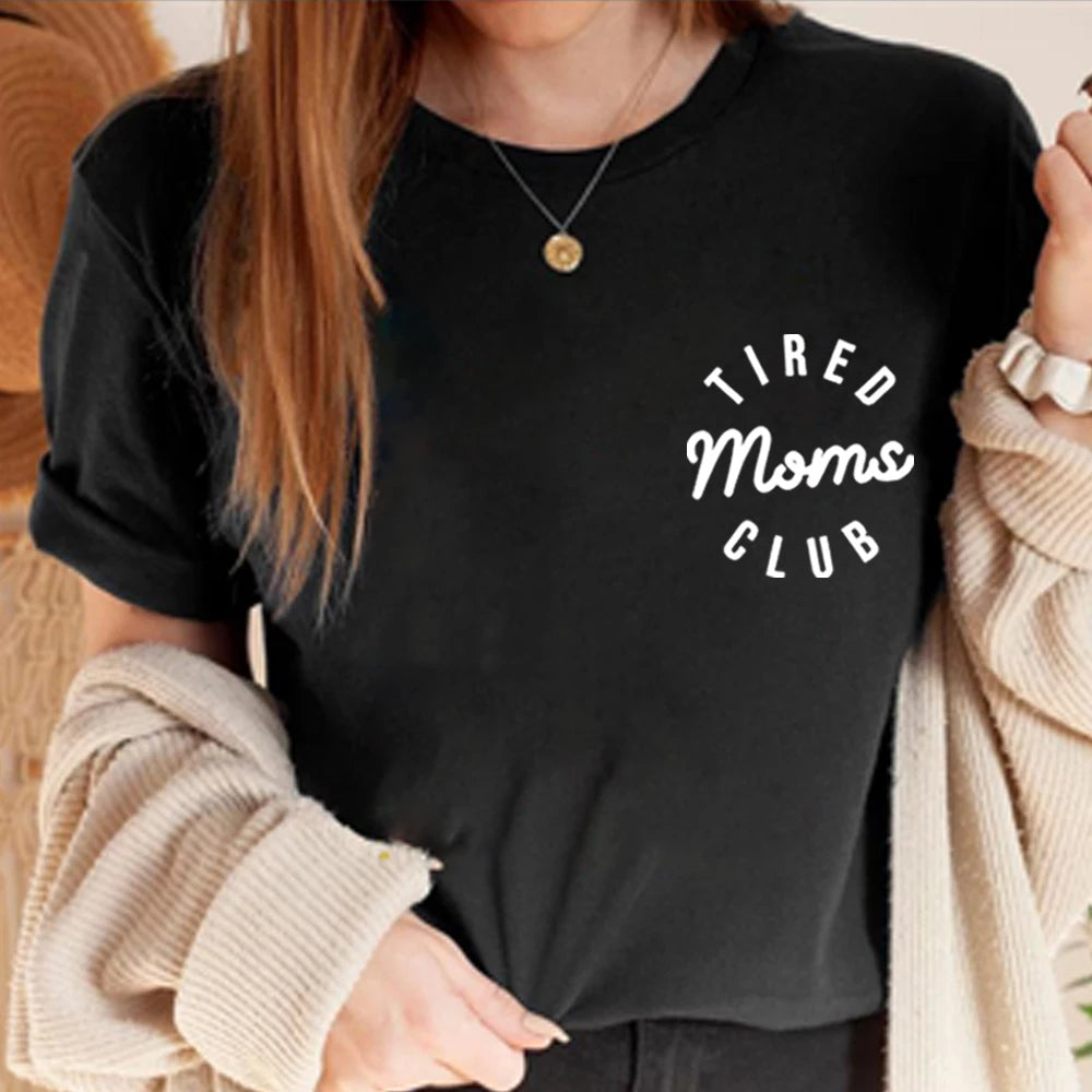 Person wearing a black sweatshirt with 'Tired Moms Club' text
