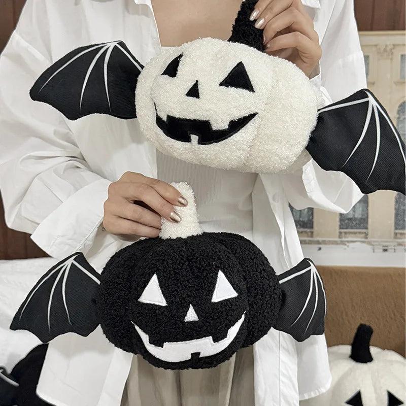 Person holding a plush toy with pumpkin and bat design in a home setting