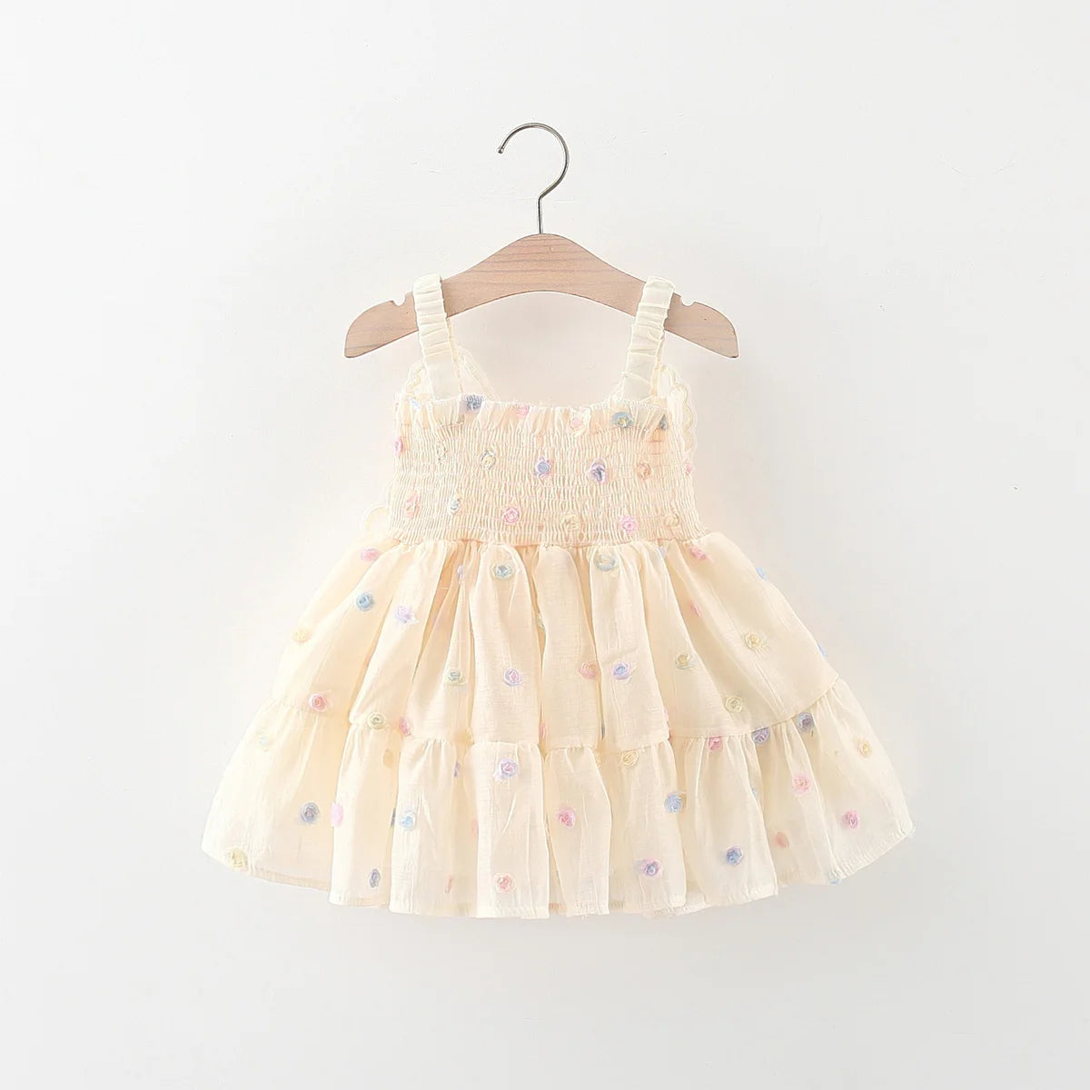Beige dress with floral patterns on a wooden hanger against a white background