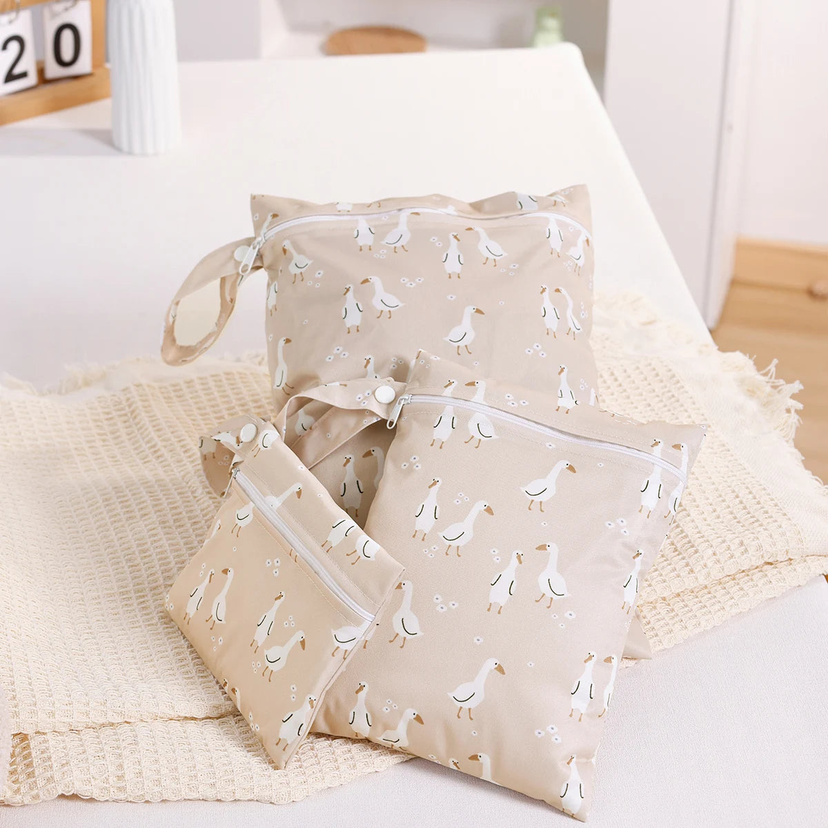 Set of beige bags with bird pattern on a white surface