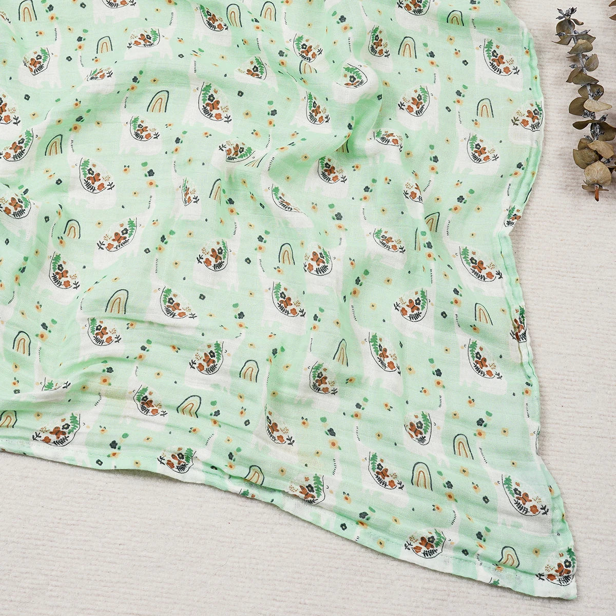 Green fabric with rainbow and cloud pattern on a light wooden surface