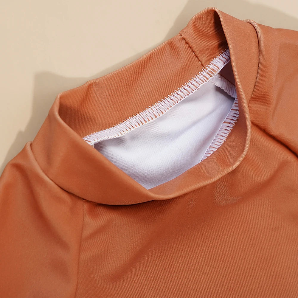 Close-up of a brown garment with white lining on a beige background