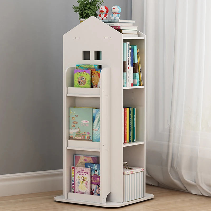 White children's bookshelf with books and toys against a gray wall.