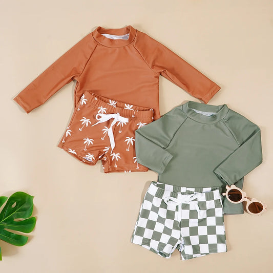 Two children's swimsuit sets with rash guards and shorts on a beige background.