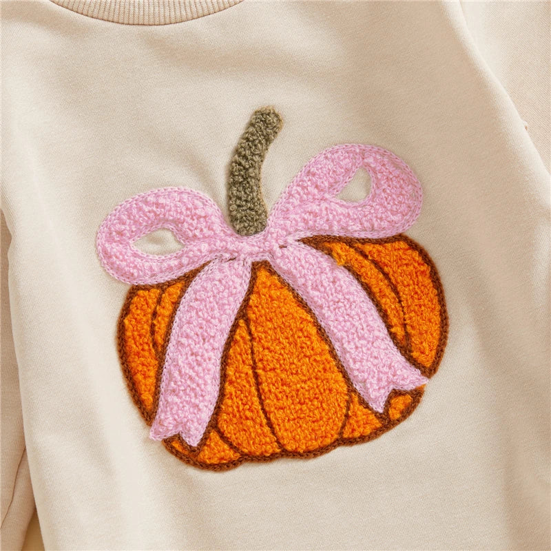 Pumpkin with pink bow patch on beige fabric