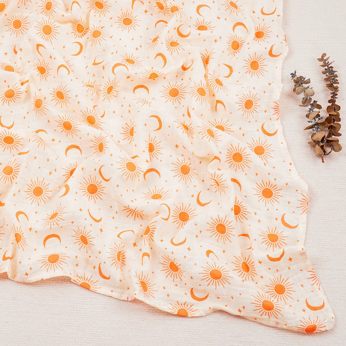 Fabric with orange sun and moon pattern on a white background
