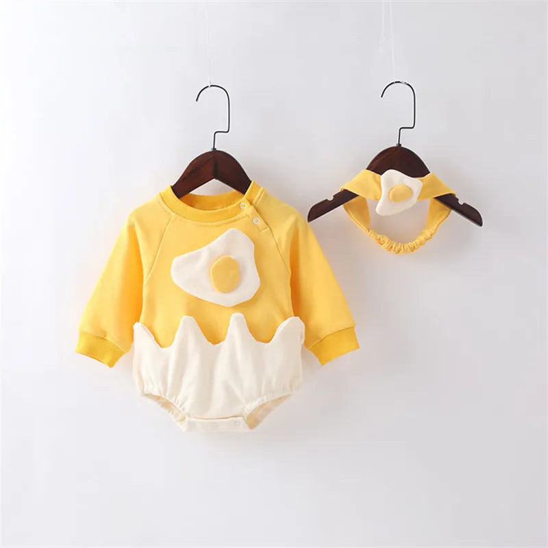 Yellow baby outfit with egg design on a white background