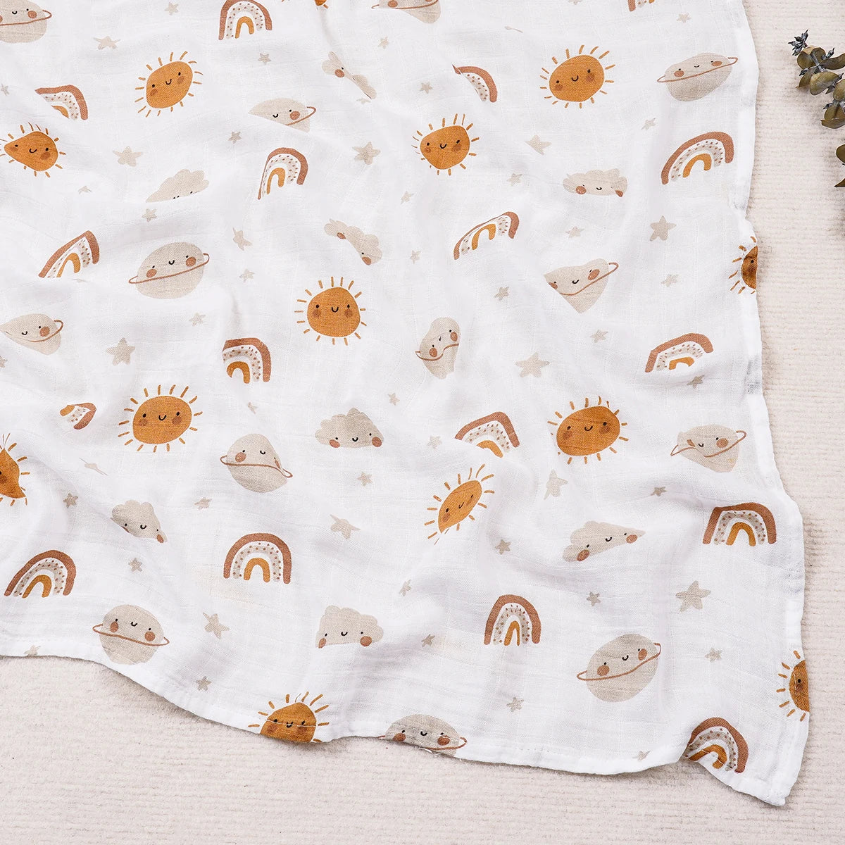 Baby blanket with sun, cloud, and rainbow pattern on a light background