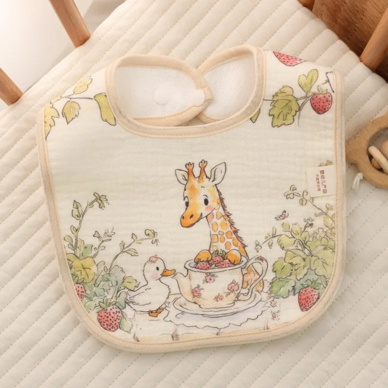 Baby bib with a giraffe and duck design on a quilted surface