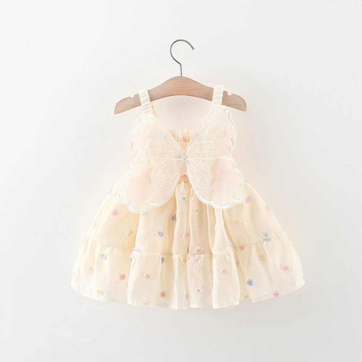 Beige dress with colorful polka dots on a wooden hanger against a white background