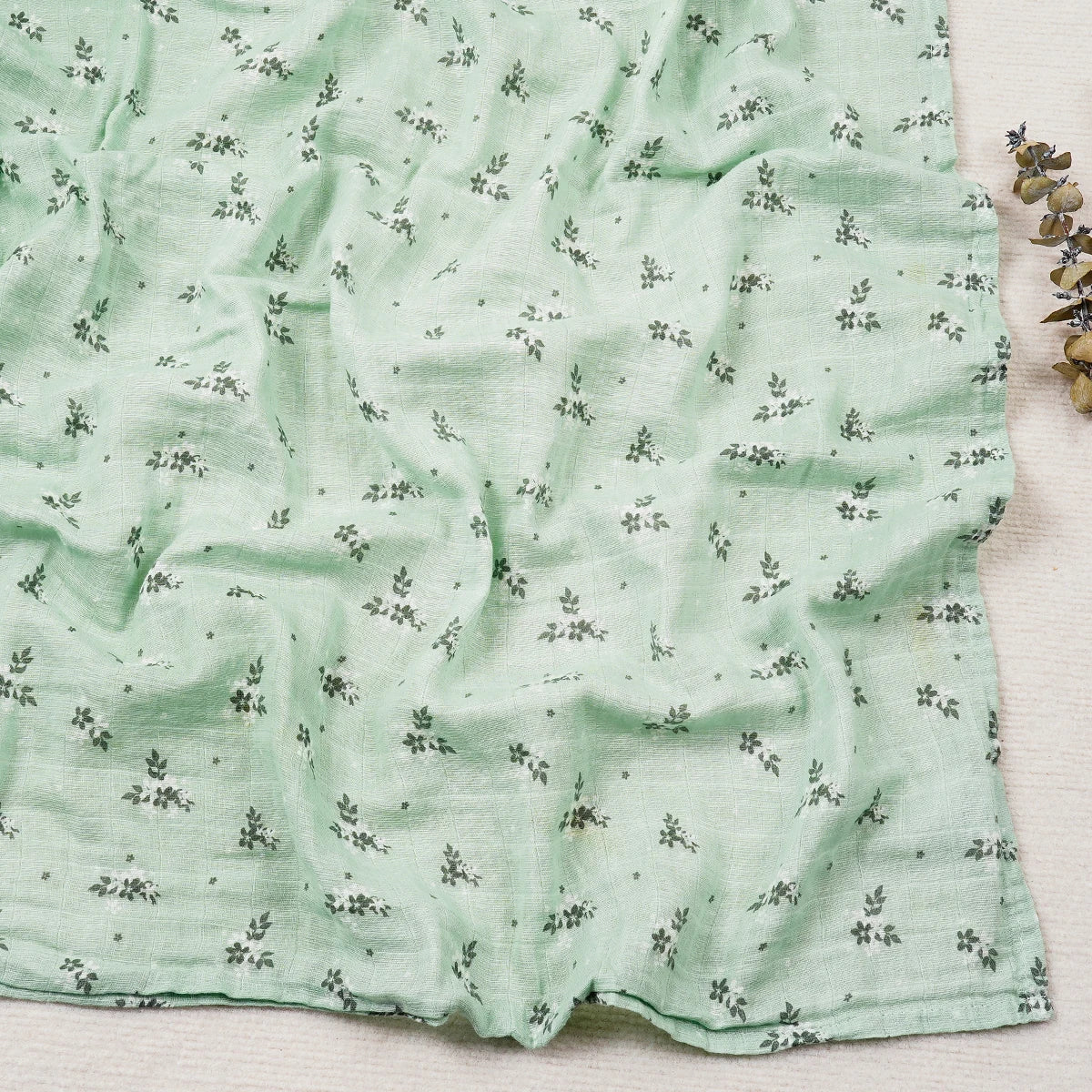 Green fabric with small patterns on a light wooden surface