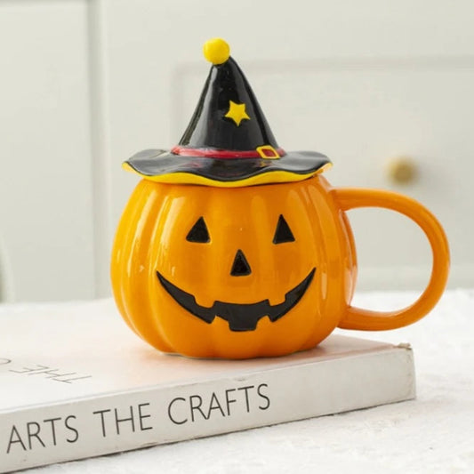 Pumpkin-shaped mug with witch hat on a book titled 'ARTS THE CRAFTS'.