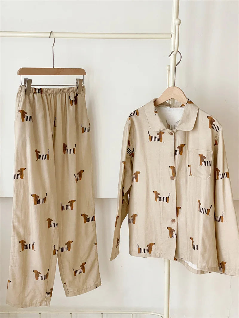 Beige pajama set with dog pattern on hangers against a white background