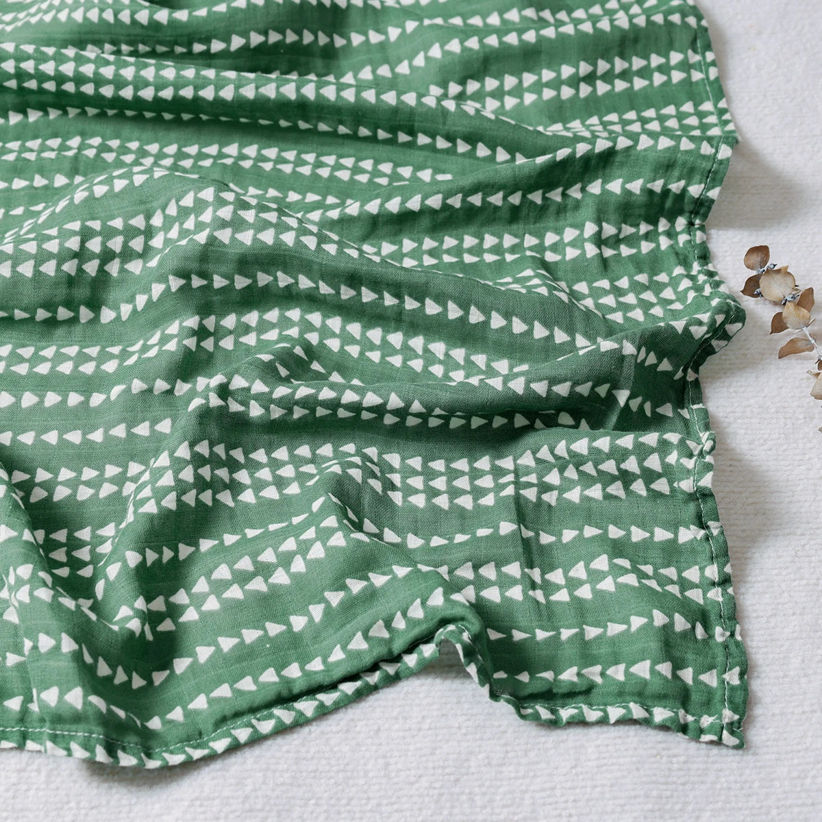 Green fabric with white triangle pattern on a light gray background
