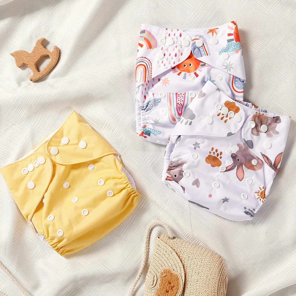 Three baby diapers with animal prints on a white surface