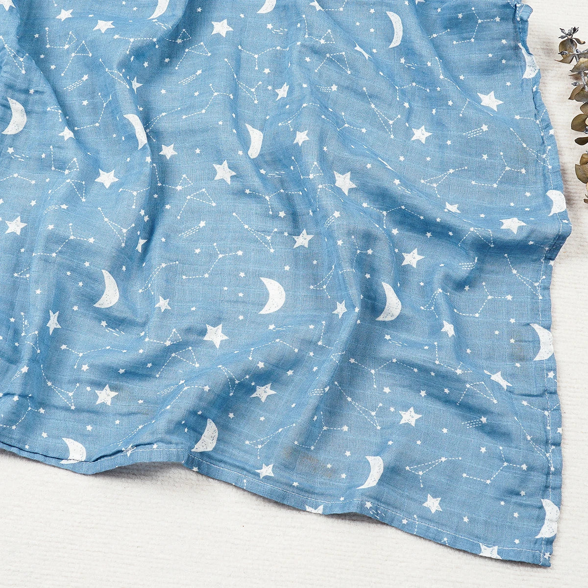 Blue fabric with white star and moon pattern on a light gray background