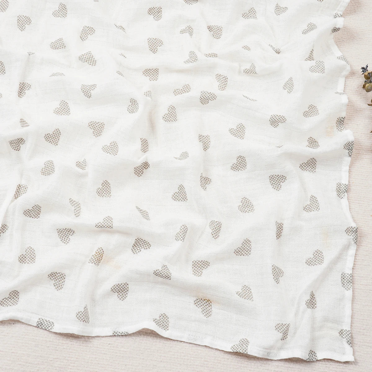 White fabric with small heart patterns on a light wooden surface
