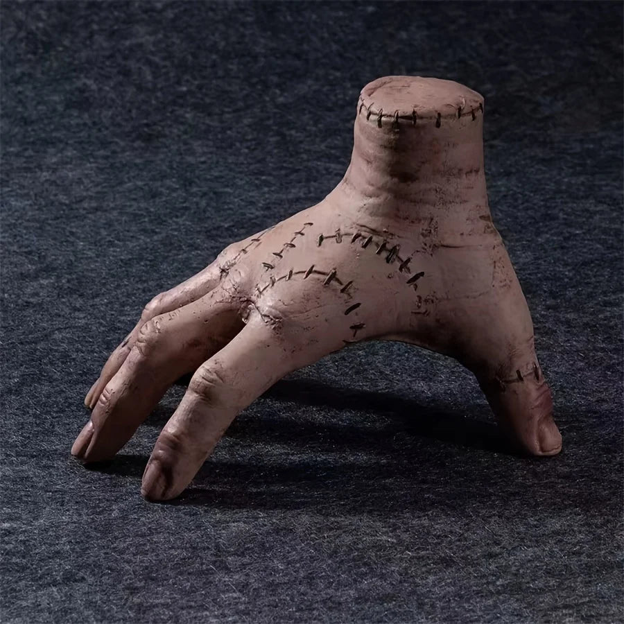 Clay sculpture of a hand with stitches on a dark textured background